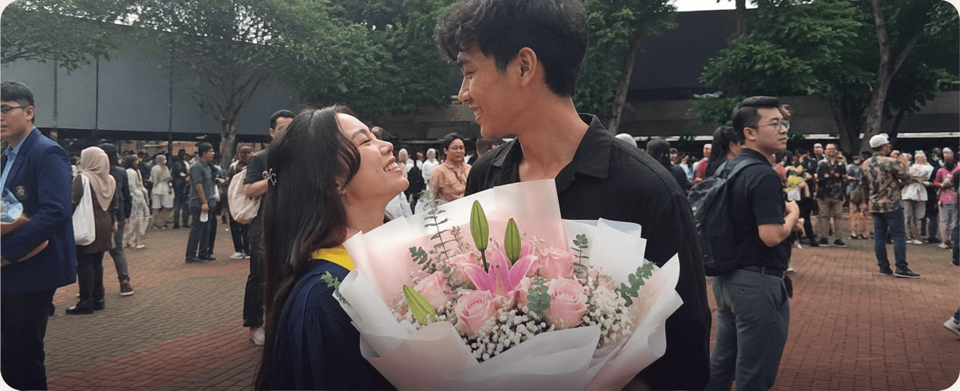 Sepasang di hari wisuda dengan buket